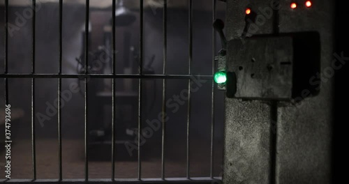 Execution concept. Death penalty electric chair miniature in selective focus inside old prison. Old prison bars cell lock. Creative artwork decoration. Electric chair scale model in the dark photo