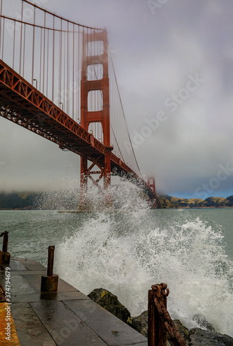 фотография Waves crashing at the famous Golden Gate bridge with low fog rolling in San Fran