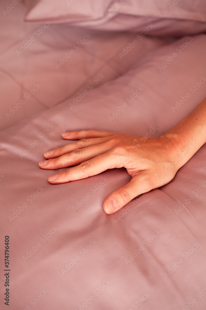 Female hand on the background of a gray bed. Close-up photo Female hand on the background of a gray bed. Close-up photo