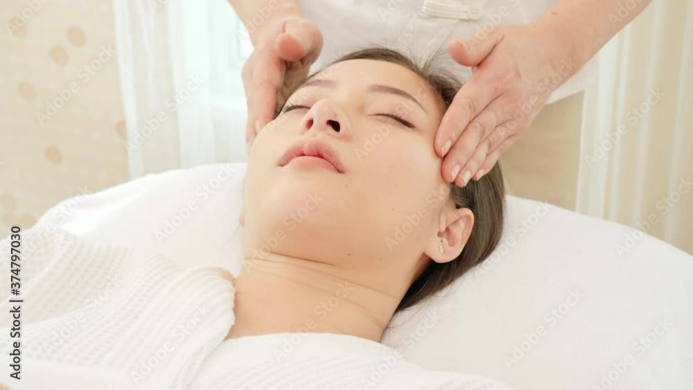 Young Asian woman getting spa massage treatment at beauty spa salon. Face massage, Relaxing massage, Spa skin and body care. Young Asian woman getting spa massage treatment at beauty spa salon. Face massage, Relaxing massage, Spa skin and body care.