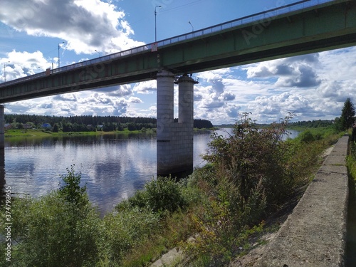 A long high concrete bridge over a wide calm river