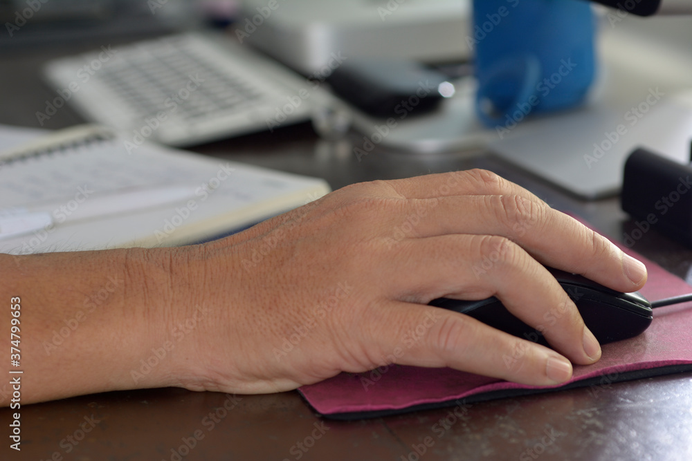 closeup of male hand with computer mouse on wooden brown table. closeup of male hand with computer mouse on wooden brown table.