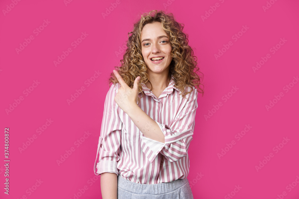 Young beautiful woman shows her finger to the left. Young beautiful woman shows her finger to the left.