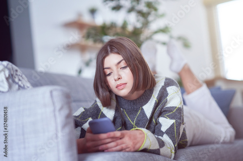 Teenage girl texting at home
