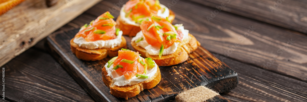 Smorrebrod or sandwich with Ricotta and salmon on the cutting board. Smorrebrod or sandwich with Ricotta and salmon on the cutting board.