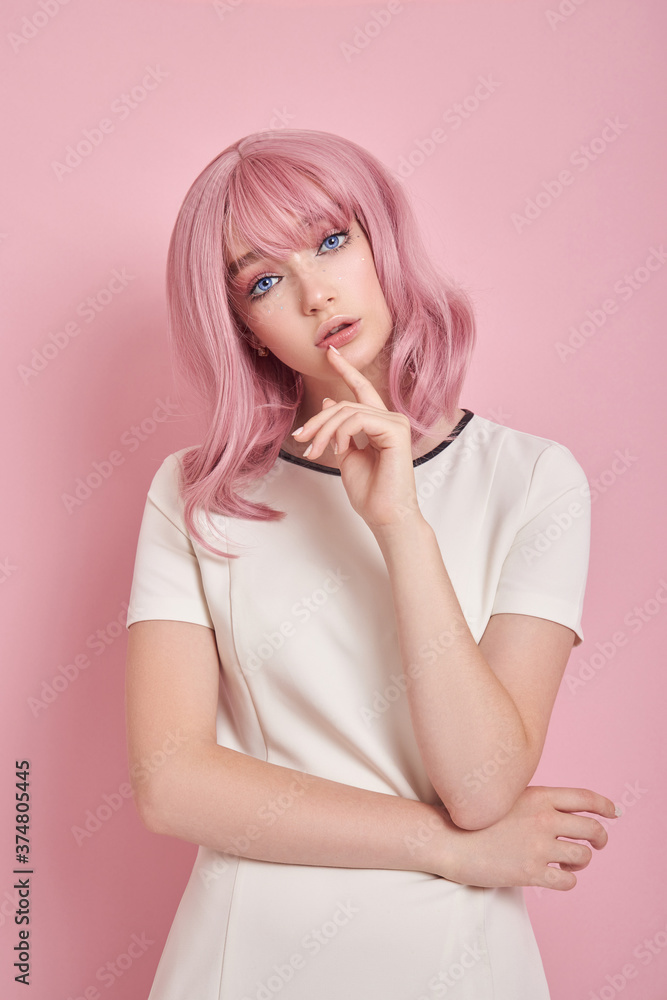Cute girl with long pink hair, hair coloring. Beautiful woman on a pink background in a white dress. Colored hair, perfect hairstyle, beauty and care Cute girl with long pink hair, hair coloring. Beautiful woman on a pink background in a white dress. Colored hair, perfect hairstyle, beauty and care