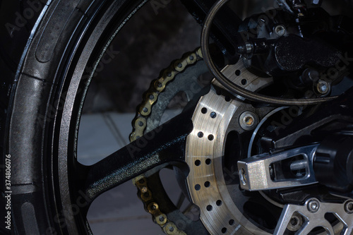 Chain, sprocket, and rear disc brakes. The rear wheel of a powerful sports motorcycle.