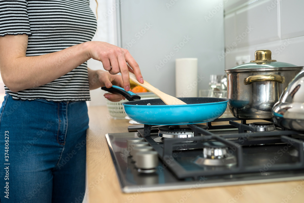 Woman cooking food on kitchen with frying pan on plate, fresh delicious dinner Woman cooking food on kitchen with frying pan on plate, fresh delicious dinner