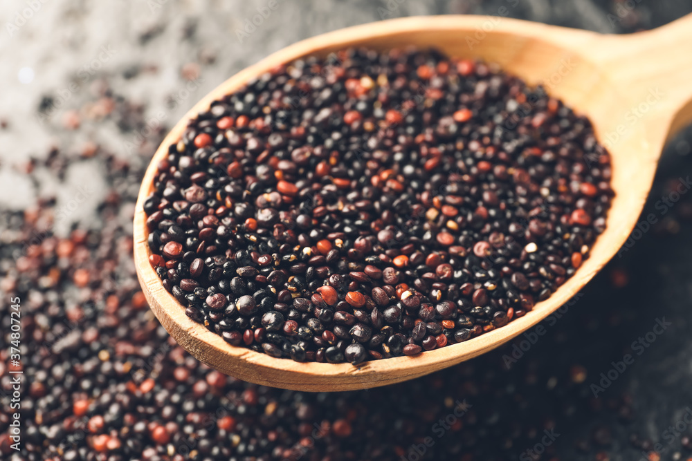 Spoon with healthy quinoa on dark background, closeup Spoon with healthy quinoa on dark background, closeup