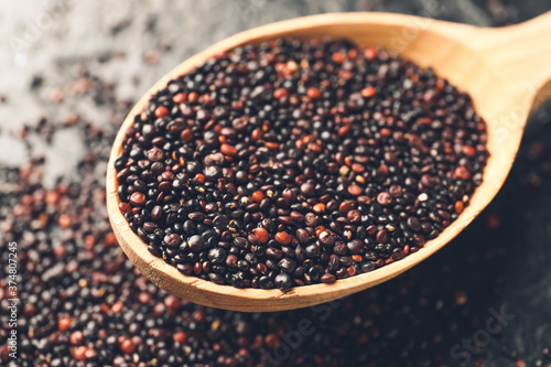 Black quinoa seeds in woode...
