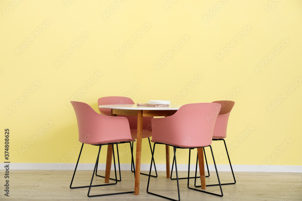 Fototapeta premium Dining table near color wall