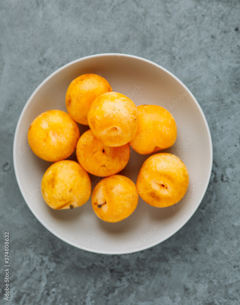 yellow plum fruit on grey concrete background with copy space yellow plum fruit on grey concrete background with copy space