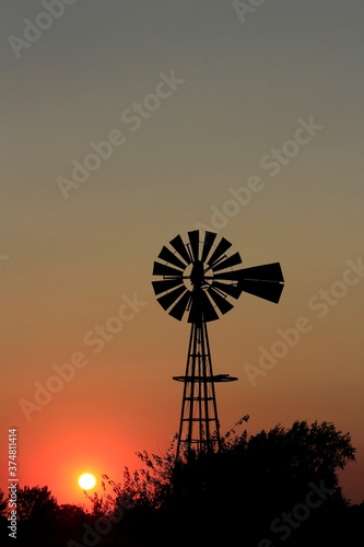 windmill at sunset with silhouette's in Kansas.
