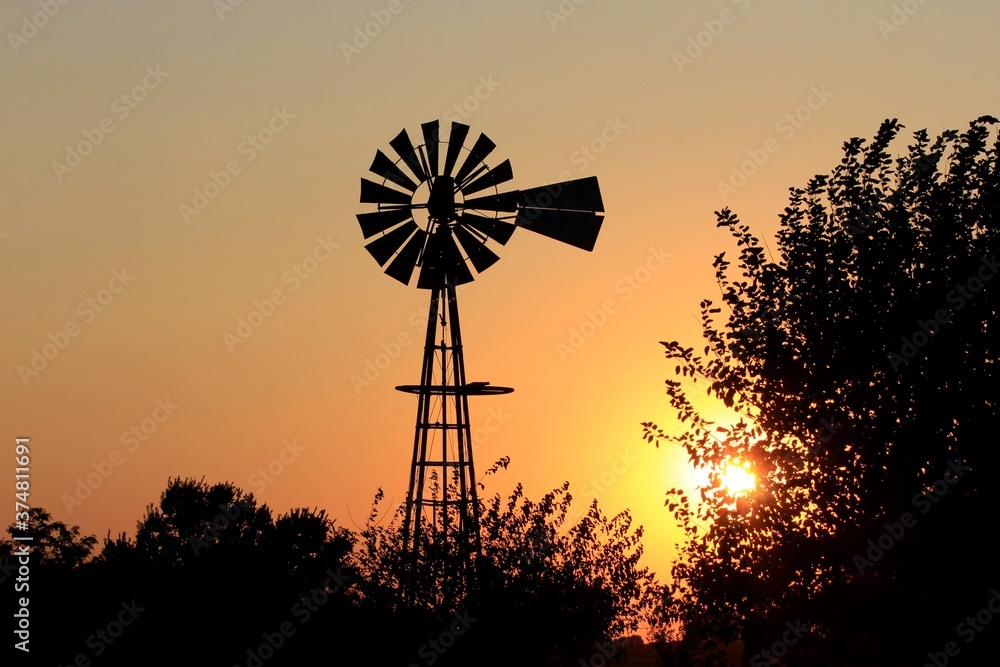 windmill at sunset with silhouette's in Kansas. windmill at sunset with silhouette's in Kansas.
