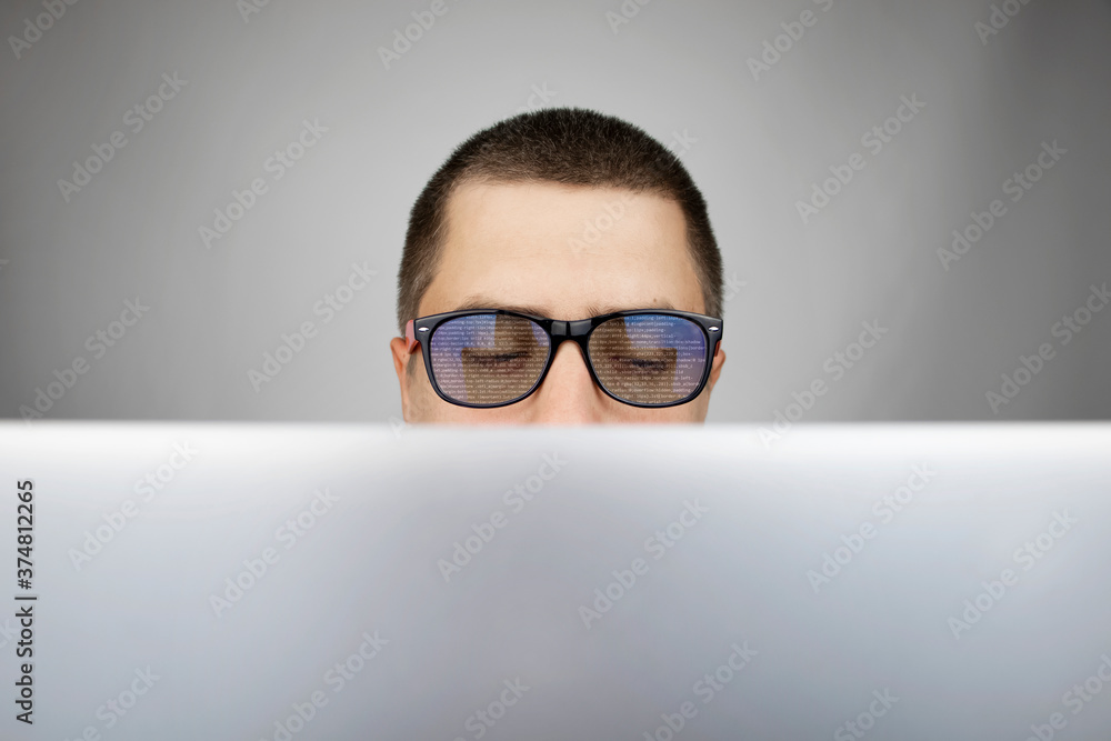 The programmer's glasses reflect lines of code. Programming, development of applications, sites and other things. Software development concept The programmer's glasses reflect lines of code. Programming, development of applications, sites and other things. Software development concept