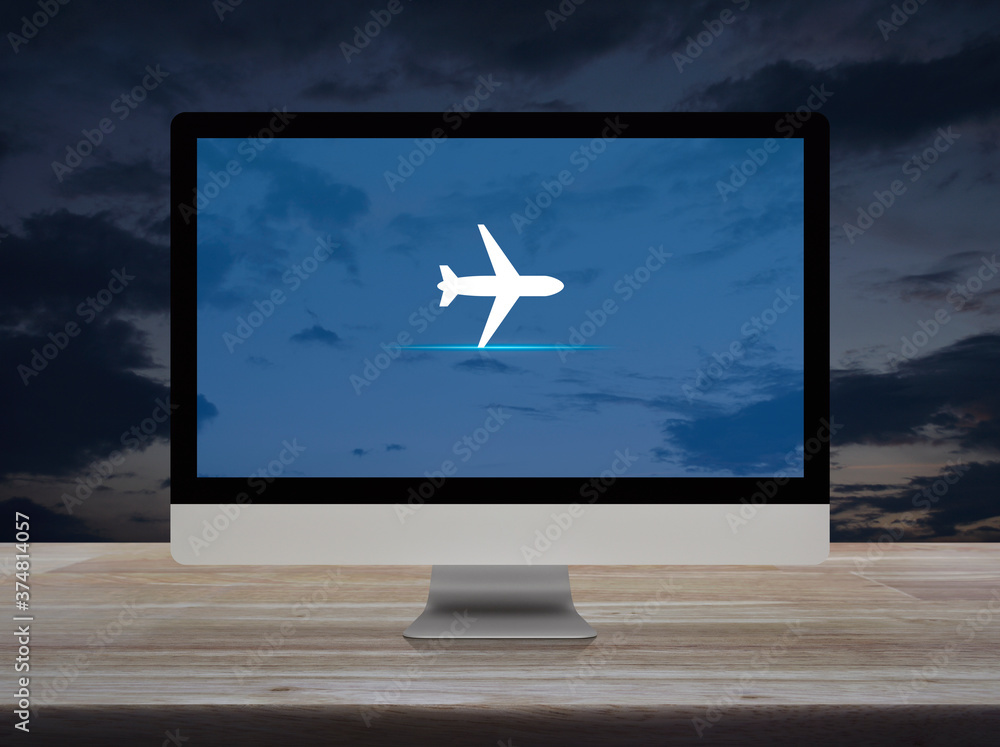 Airplane flat icon on desktop modern computer monitor screen on wooden table over sunset sky, Business transportation online concept Airplane flat icon on desktop modern computer monitor screen on wooden table over sunset sky, Business transportation online concept