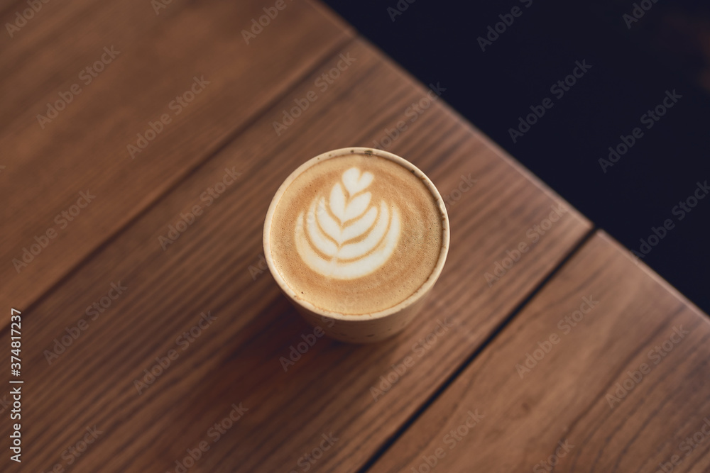 Cup of cappuccino with latte art on the wooden table. Beautiful foam and ceramic cup Cup of cappuccino with latte art on the wooden table. Beautiful foam and ceramic cup