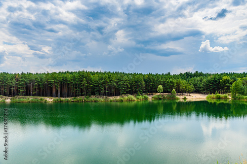 View on a lake in the abandoned sand quarry and dramatic sky