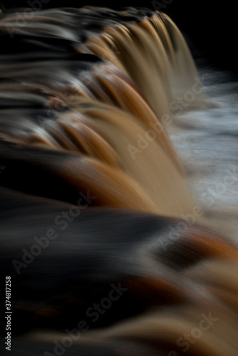 Overhead view of waterfall in Swaledale North Yorkshire. Brown polluted flowing river. 