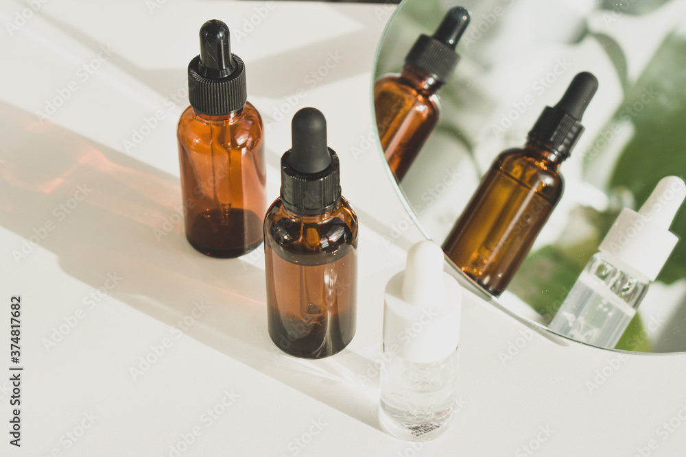 Spa cosmetics in brown glass bottles on a white table. Beauty blogger, salon therapy, branding layout, minimalism concept. Top view, copy space Spa cosmetics in brown glass bottles on a white table. Beauty blogger, salon therapy, branding layout, minimalism concept. Top view, copy space