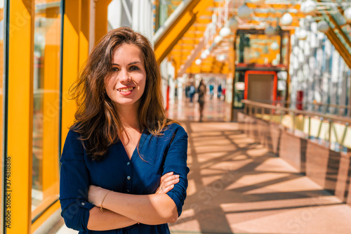 Portrait of a successful young woman in a bright modern space on the yellow pedestrian bridge in Moscow