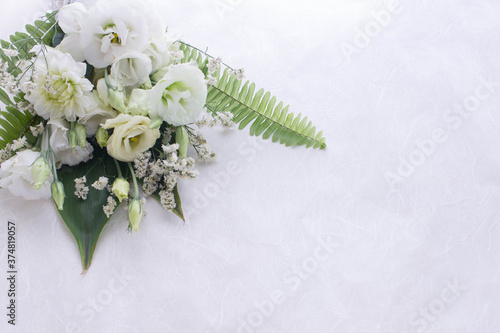 Flower arrangement of several kinds of white flowers and leaves.