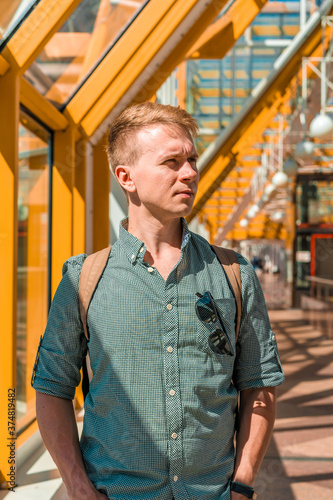Portrait of a successful young man in a bright modern space on the yellow pedestrian bridge in Moscow