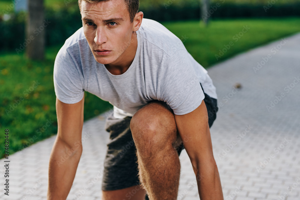 sports man in sneakers shorts and a t-shirt running in the park outdoors fitness sports man in sneakers shorts and a t-shirt running in the park outdoors fitness
