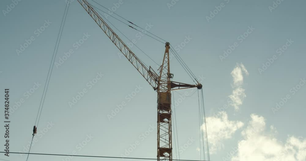 Crane and building under construction against blue sky Crane and building under construction against blue sky