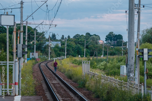 A man walking on railway tracks.