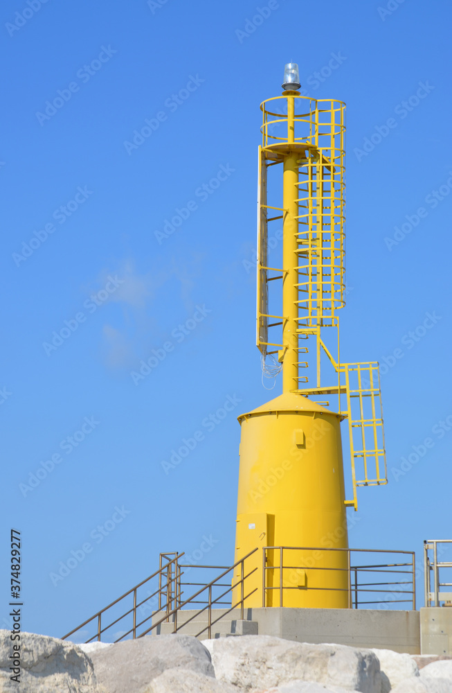 yellow lighthouse with metal structure on concrete base yellow lighthouse with metal structure on concrete base