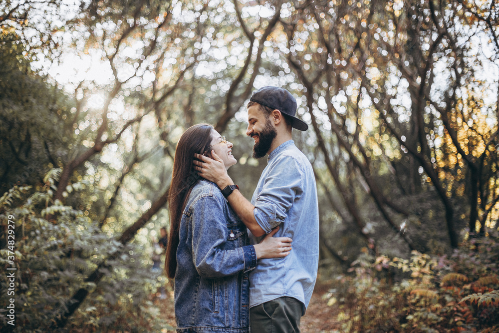 stylish hipster couple in love dressed in denim walks in the autumn park stylish hipster couple in love dressed in denim walks in the autumn park