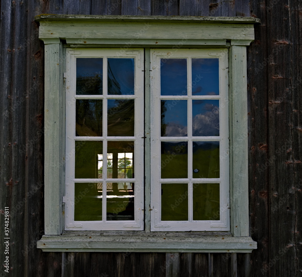 Fototapeta premium Classical old window with white window frame and brown varnished wooden walls.