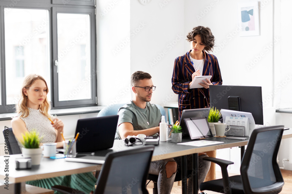 business, people and corporate concept - team of startuppers working at office business, people and corporate concept - team of startuppers working at office