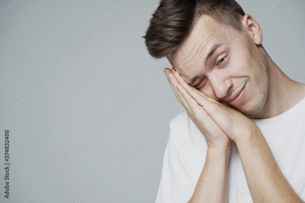 a lazy male student wakes up early in the morning, looking rumpled and sleepy. time to get ready for College. white t-shirt and grey background. place a banner ad for a company a lazy male student wakes up early in the morning, looking rumpled and sleepy. time to get ready for College. white t-shirt and grey background. place a banner ad for a company