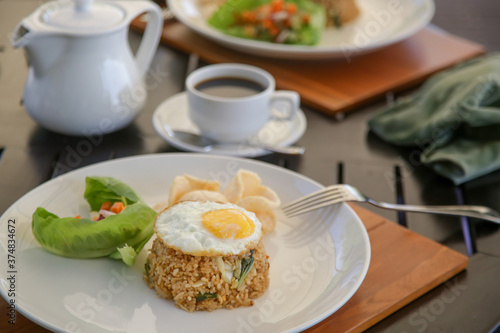 Fried rice served with fried egg and a cup of coffee