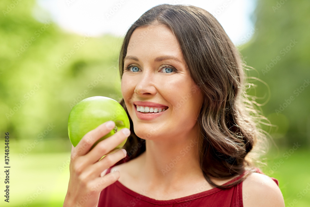 healthy eating, dental and people concept - portrait of happy woman with green apple at summer park healthy eating, dental and people concept - portrait of happy woman with green apple at summer park
