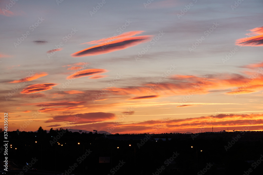 Fototapeta premium The last rays of the sun cast their reddish and orange colors into the clouds. Madrid. Spain