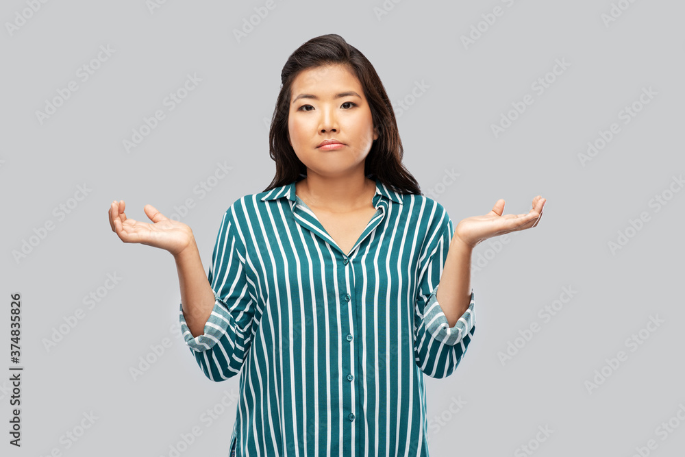 people, gesture and emotion concept - sad asian young woman shrugging over grey background people, gesture and emotion concept - sad asian young woman shrugging over grey background