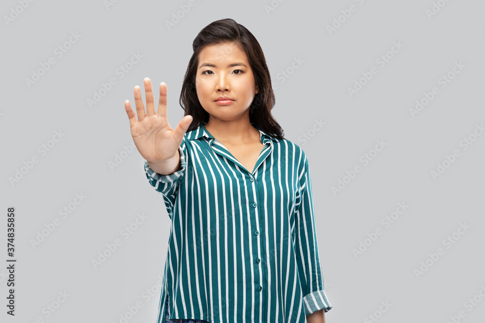 people, prohibition and rejection concept - asian young woman showing stop gesture over grey background people, prohibition and rejection concept - asian young woman showing stop gesture over grey background