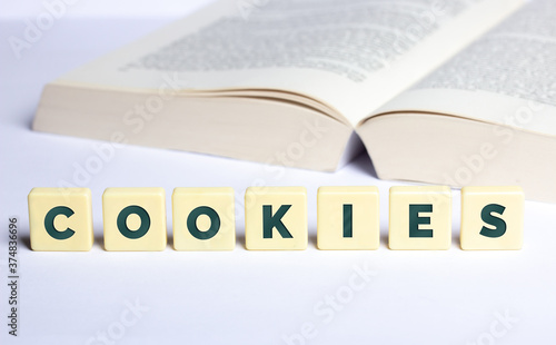 Das Wort Cookies mit geöffnetem Buch im Hintergrund
