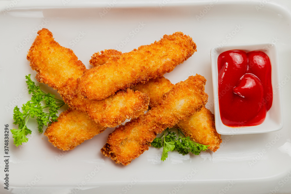 Fresh crispy nuggets with tomato sauce on a white plate. Fresh crispy nuggets with tomato sauce on a white plate.