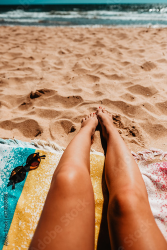 Legs of a girl lying on the beach.