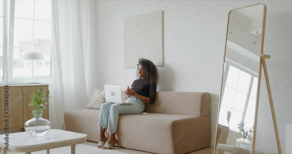 Young adult Black African American female having a video conference call at home. 60 FPS slow motion 4K UHD RAW Graded footage Young adult Black African American female having a video conference call at home. 60 FPS slow motion 4K UHD RAW Graded footage