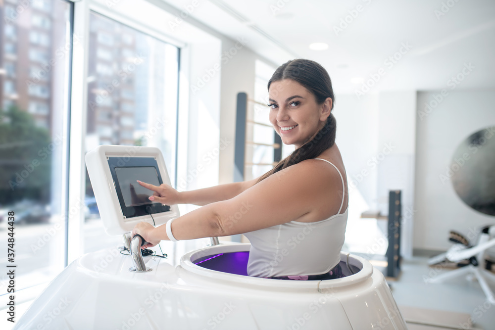 Smiling woman using a novel treadmill in a gym Smiling woman using a novel treadmill in a gym