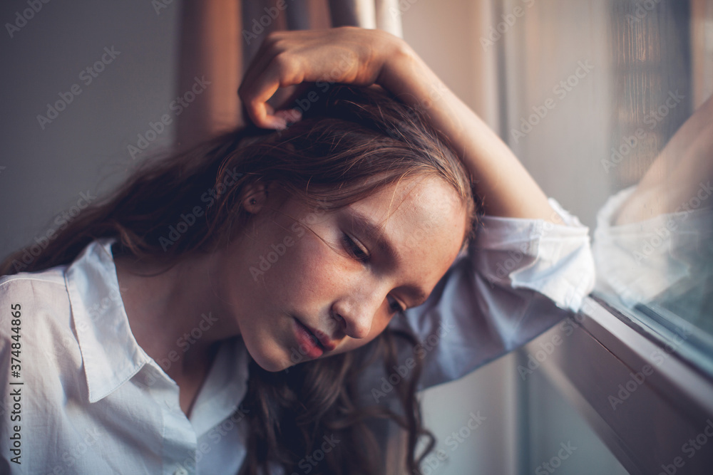 Fototapeta premium Sad teen near window