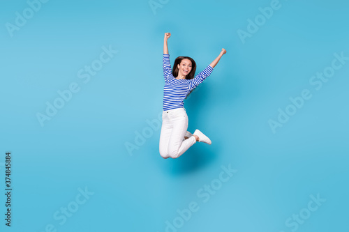 Full length body size view of her she nice attractive pretty cheerful cheery lucky successful girl jumping having fun rejoicing isolated bright vivid shine vibrant blue color background