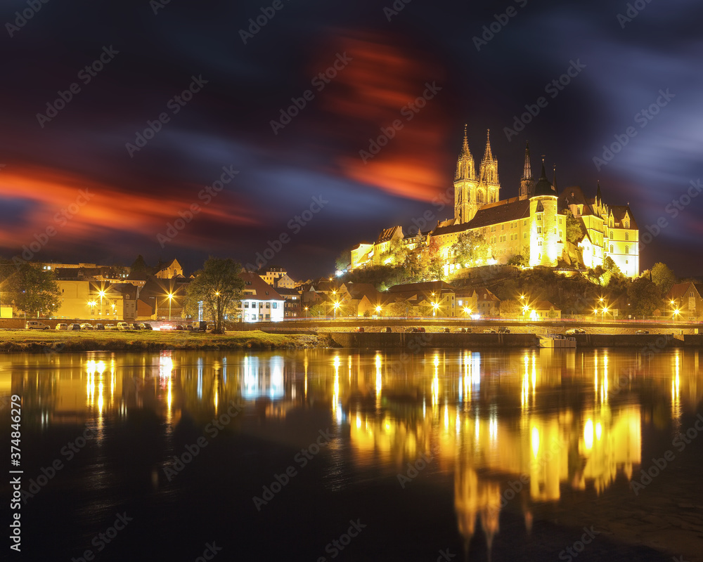 Obraz premium Dramatic view on Albrechtsburg castle and cathedral on the River Elbe during night.