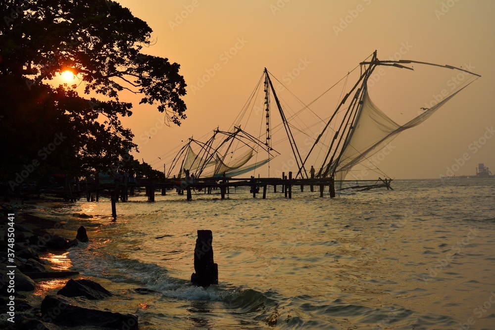 Stationary Chinese fishing nets (“Cheena vala” in Telugu) or shore operated lift nets at the sunset in Kochi Fort, Cochin, India