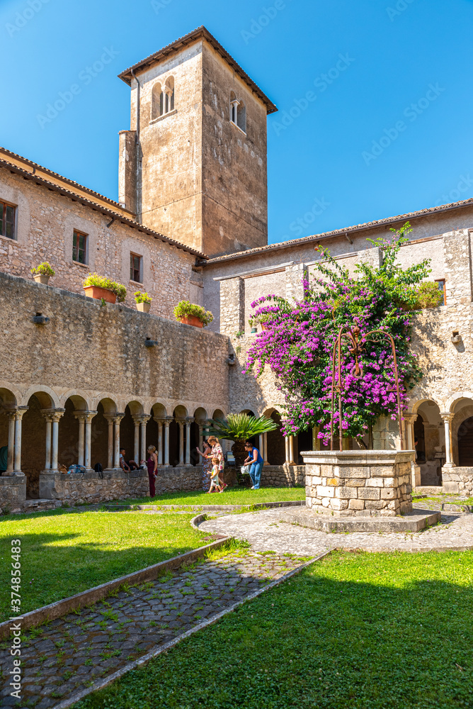 Sermoneta, Italy. June 28th, 2020. Valvisciolo Abbey. Internal cloister with wonderful bougainvillea bloom and strolling visitors.